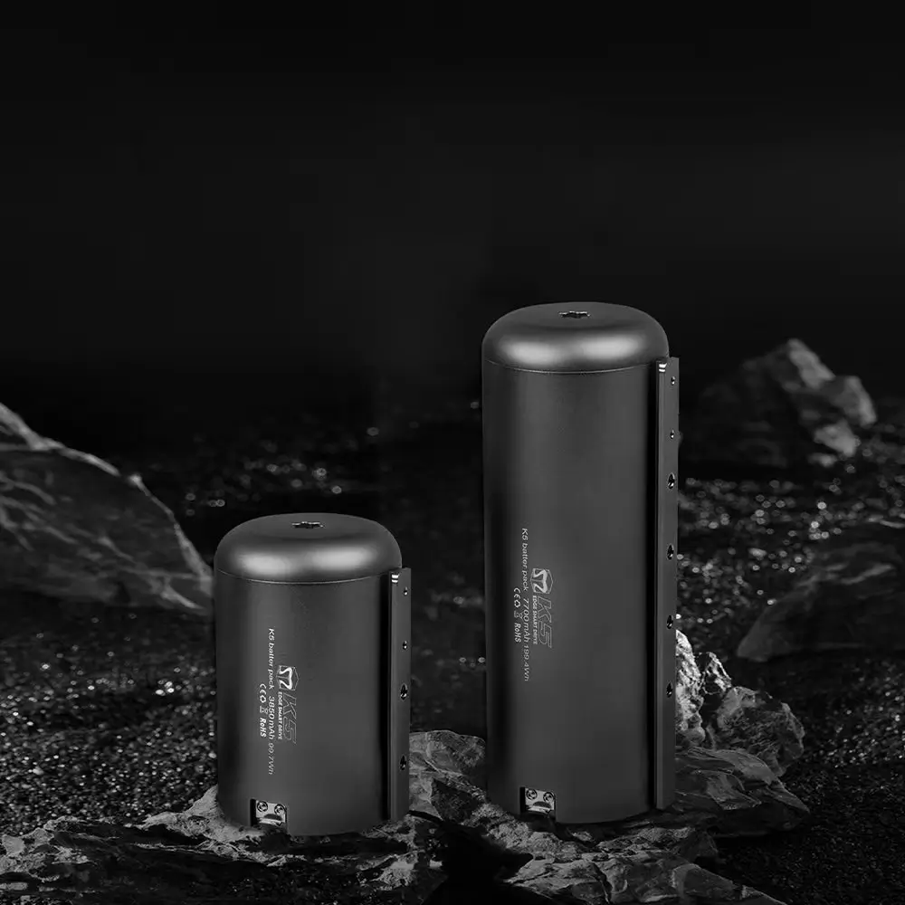 Side-by-side comparison of TEDGIX K5 waterproof batteries: Standard 99Wh (Airline Safe) vs Extended 199Wh (Long Range) on rugged terrain.