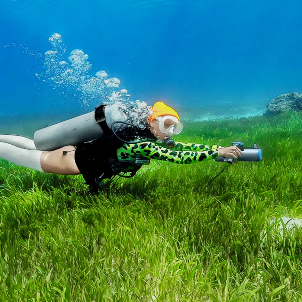 Freediver gliding over seagrass beds in clear shallow water using the TEDGIX K5 electric sea scooter for snorkeling.